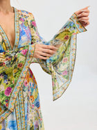 A model showcases the Social Queen Garden Print Silk Maxi Dress, featuring wide, flowing sleeves, against a plain background.