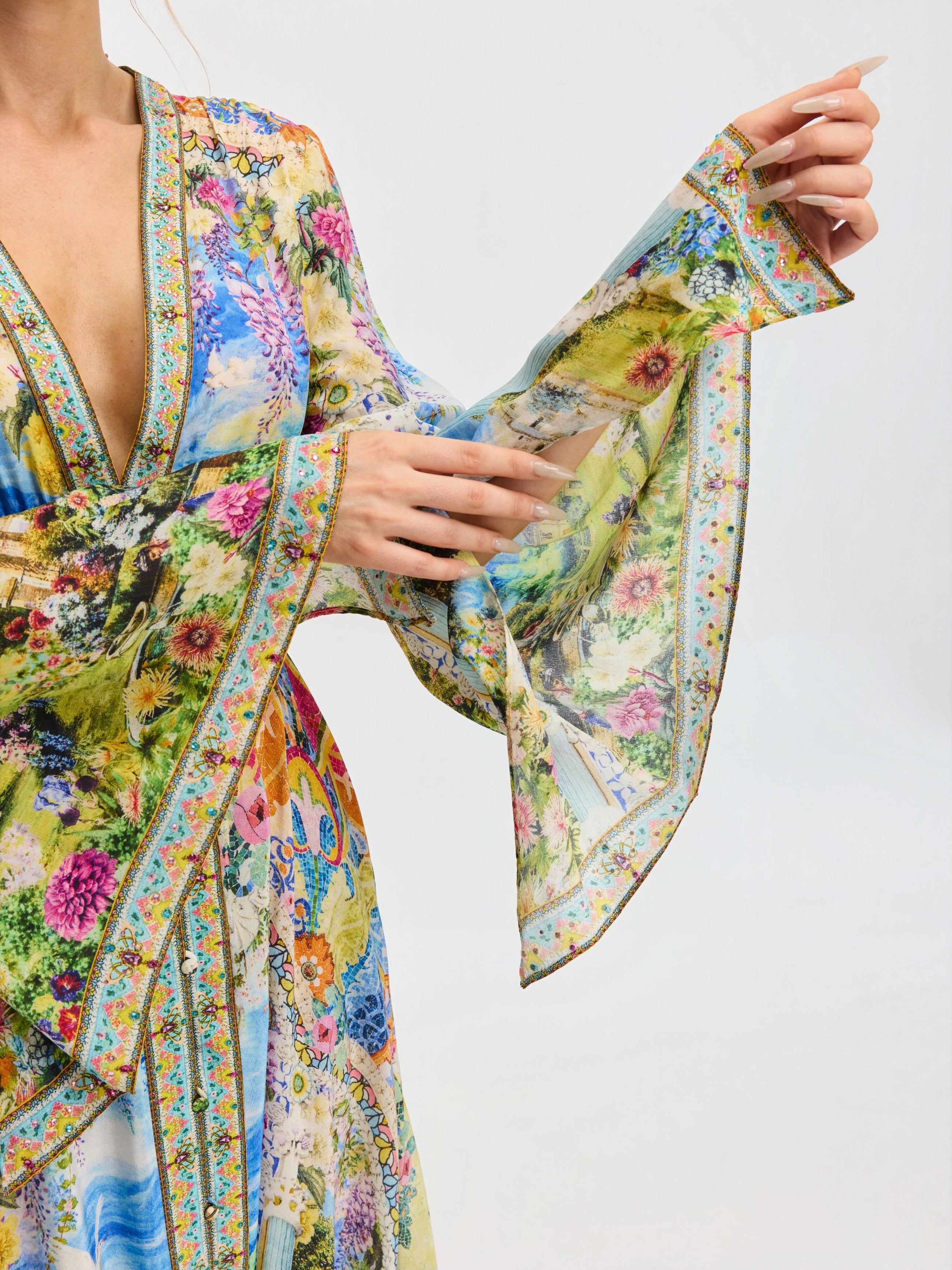 A model showcases the Social Queen Garden Print Silk Maxi Dress, featuring wide, flowing sleeves, against a plain background.