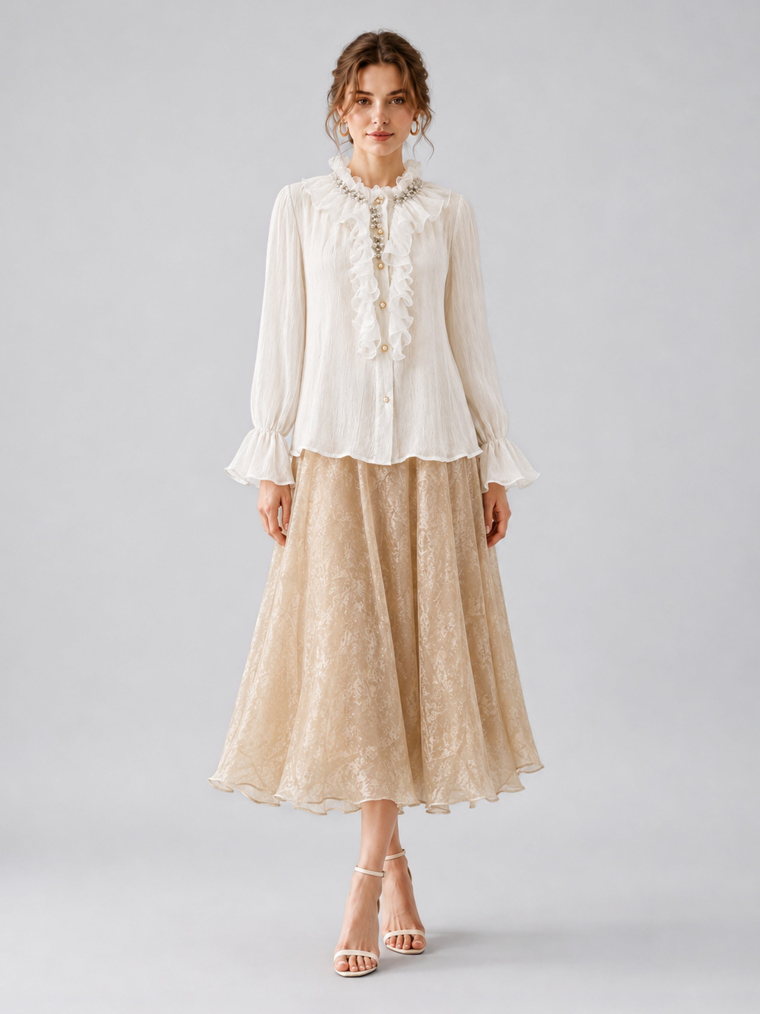 A woman is standing against a plain background wearing the Social Queen Pearl Embellished Ruffle Collar Blouse, a beige lace midi skirt, and nude heels.