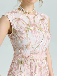 A person wearing the Social Queen Gold Floral Embroidered Dress with a pearl necklace, set against a plain background.