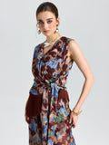 A woman models the Social Queen Floral Print Fringe Tie-Front Top with statement earrings and bracelets against a plain light background.