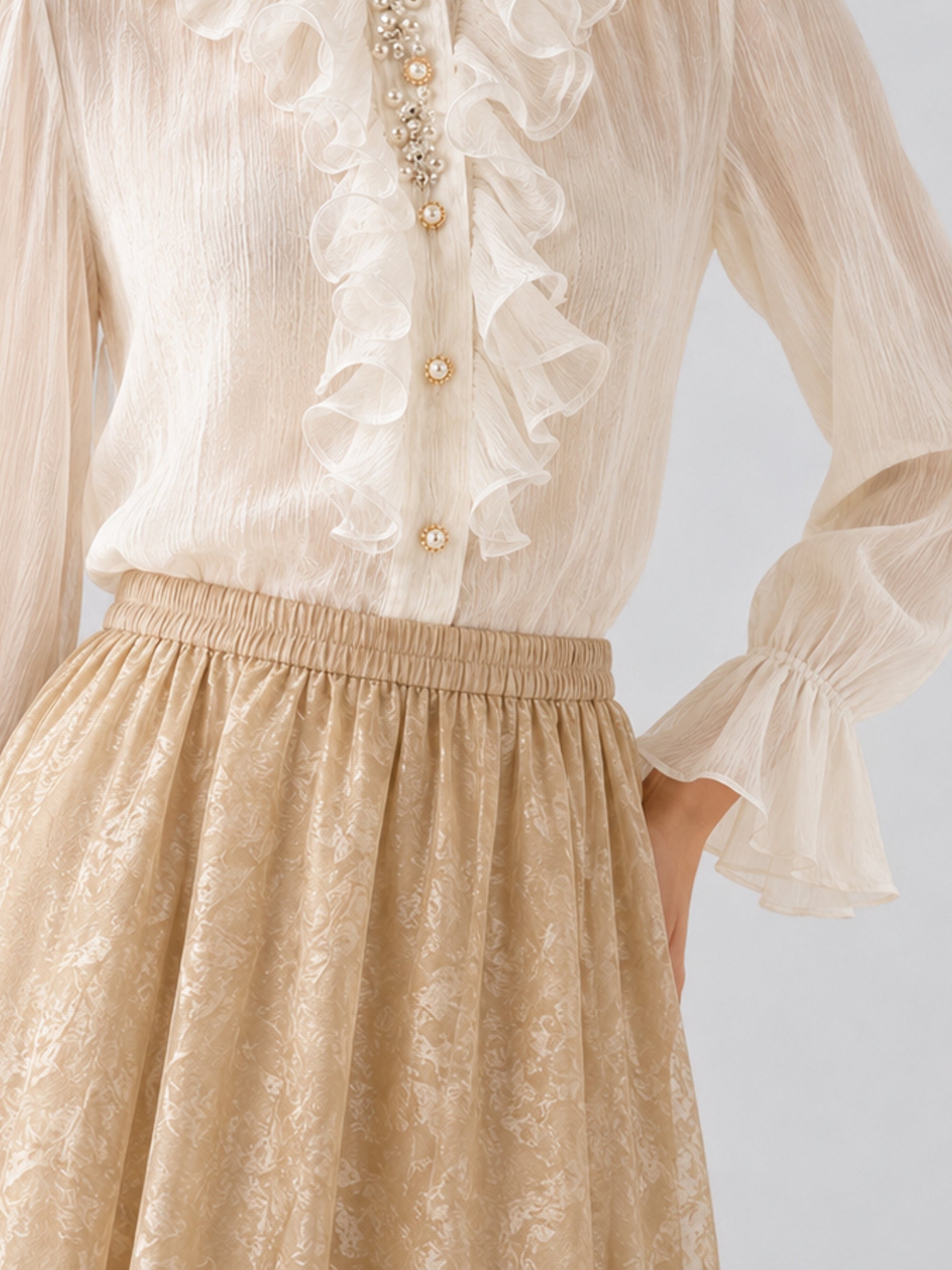 A person wears a sheer ivory blouse with ruffles and pearl buttons, paired with the Social Queen Jacquard Chiffon Midi Skirt, which features a delicate jacquard texture.
