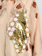 The Social Queen Placement Embroidered Linen Dress is beige with brown embroidered leaves, a damask scroll motif, and a bold gold sequin floral accent on the chest.