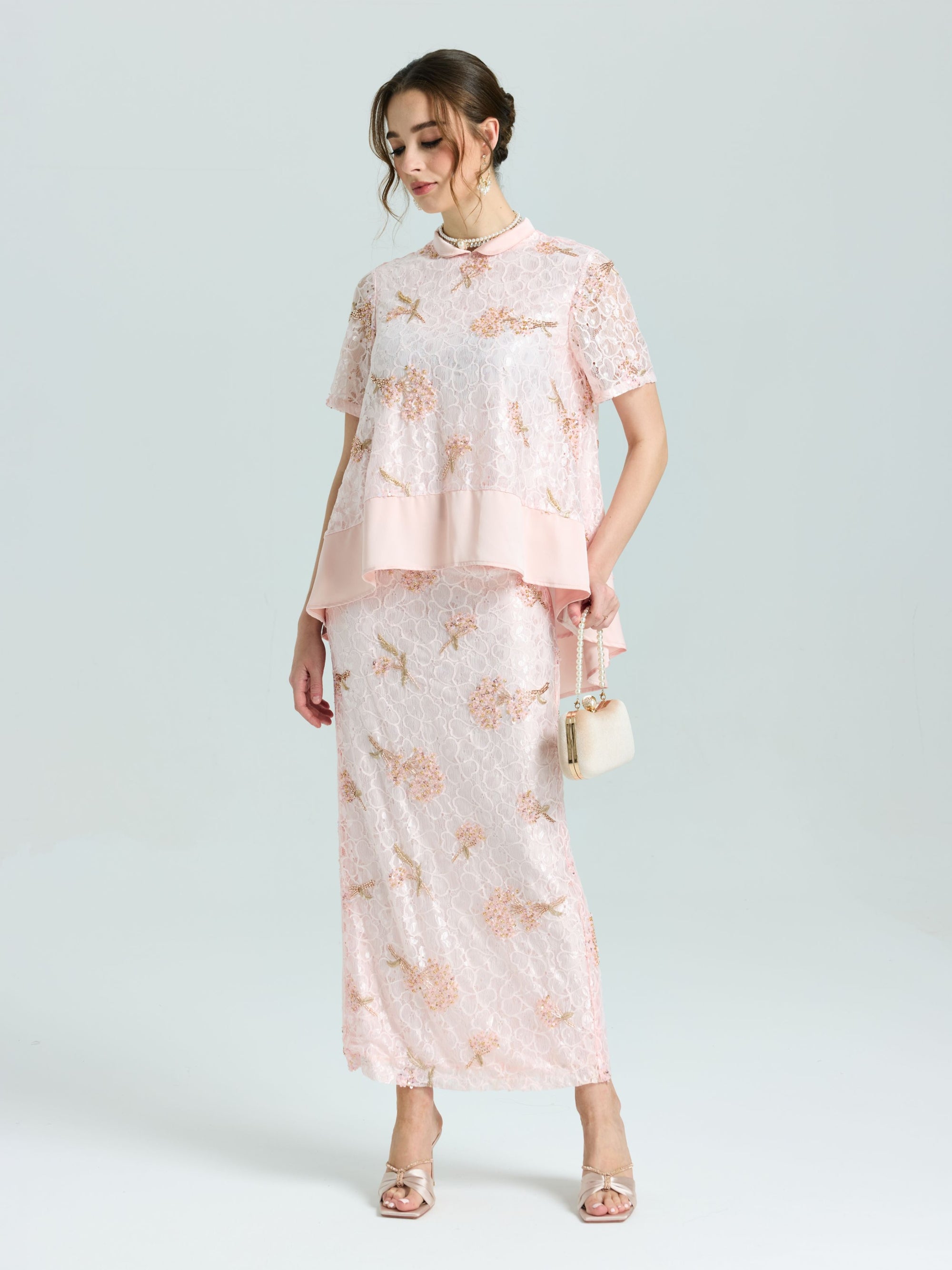 A woman wears the Social Queen Dragonfly Beaded Lace Top with a matching long skirt, standing against a plain background, holding a small purse and wearing heeled sandals.