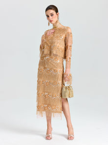 A woman wearing the Social Queen Beaded Fringe Slit Midi Skirt, paired with heeled sandals and a beaded handbag, stands against a plain light background.