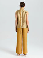 A woman faces away, wearing Social Queen’s Velvet Scarf Silk Organza Top (Cami Included) and loose mustard-yellow pants, set against a plain light background.