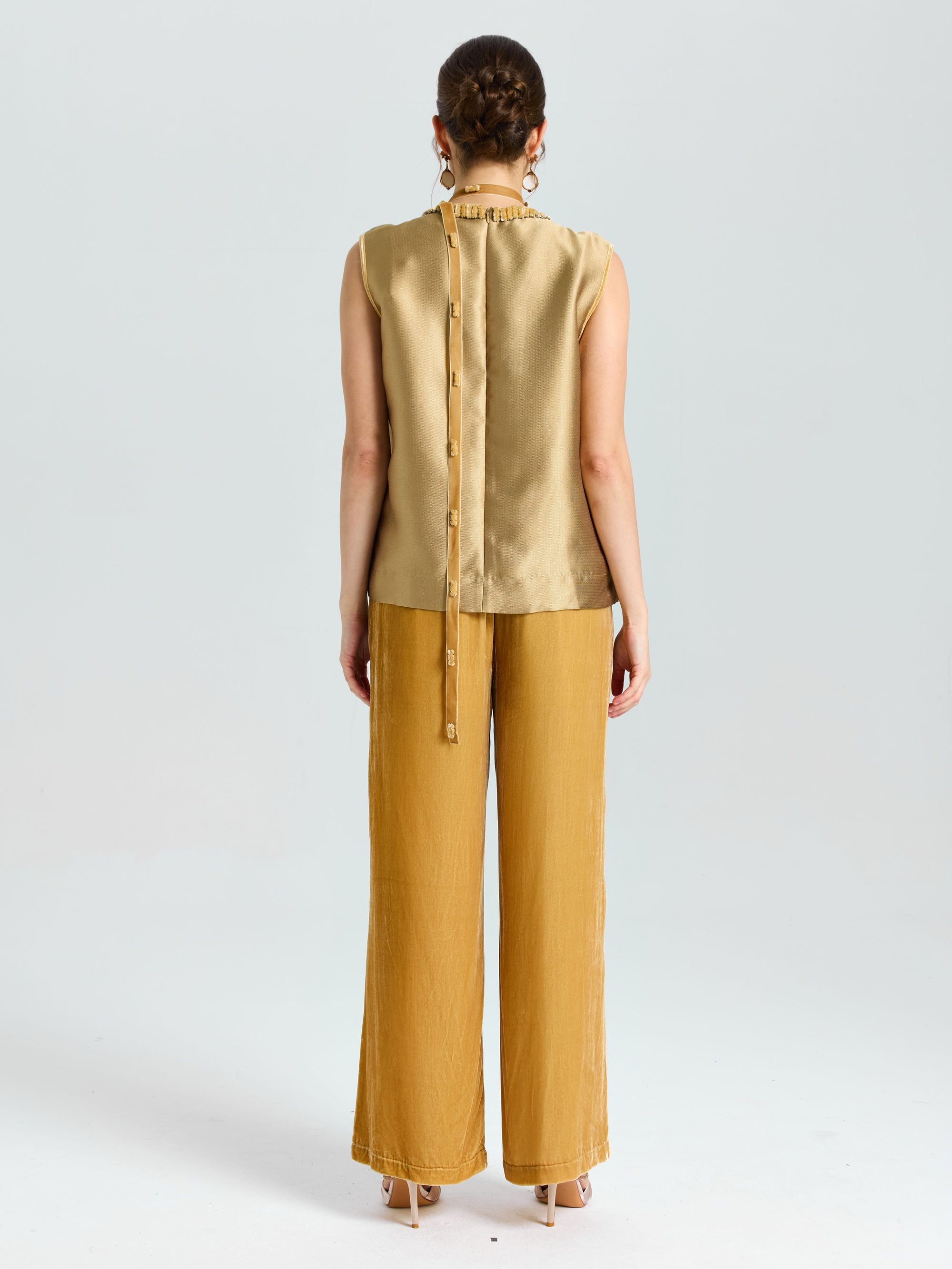 A woman faces away, wearing Social Queen’s Velvet Scarf Silk Organza Top (Cami Included) and loose mustard-yellow pants, set against a plain light background.