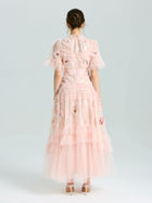 A woman in the Social Queen Embroidered Ruffle Tiered Tulle Dress stands in heels against a plain light background—the perfect special occasion look.