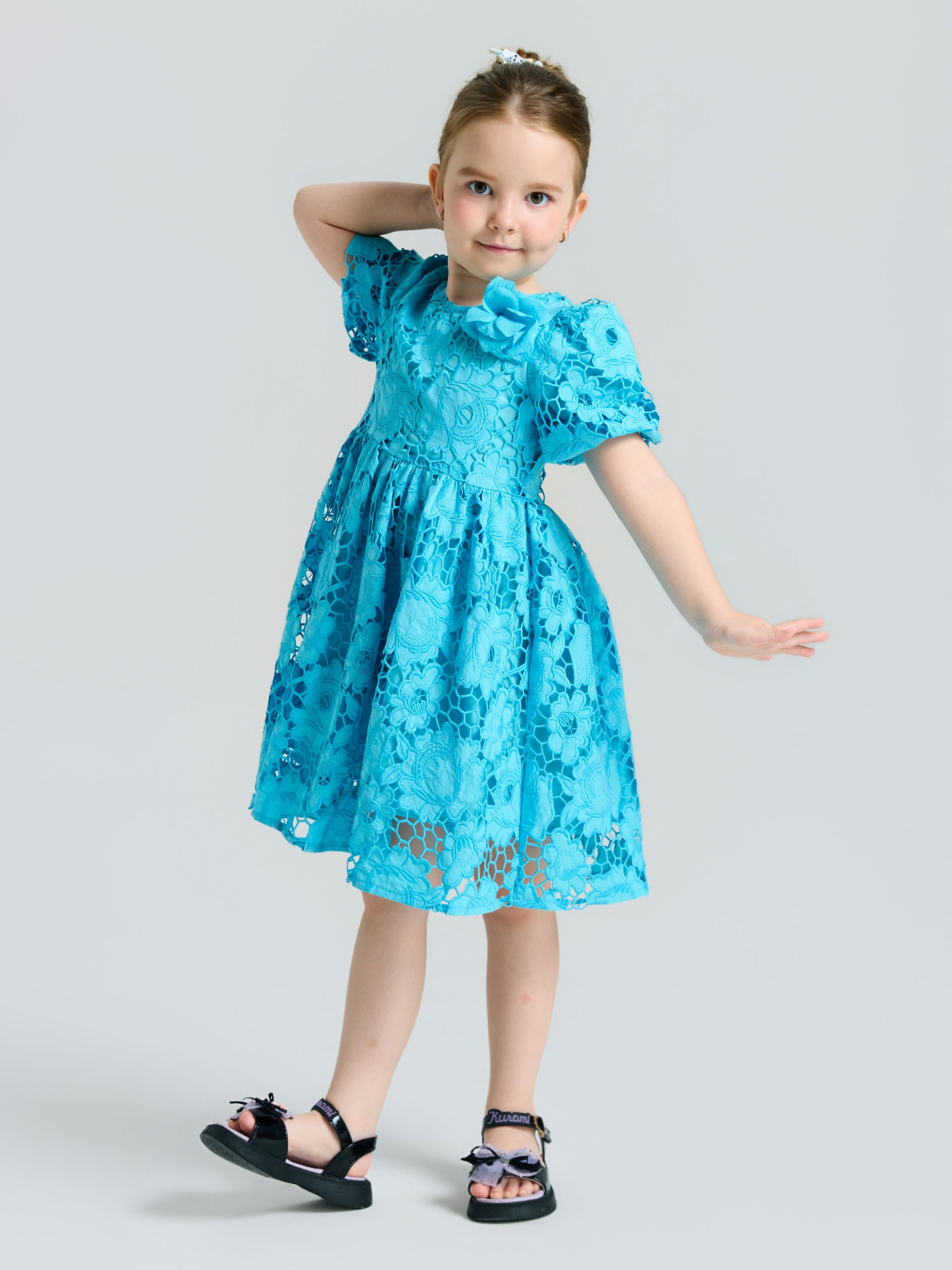 A young girl poses in the Social Queen Girls 3D Floral Appliqué Cutwork Lace Dress, featuring an A-line silhouette and blue lace details, paired with black sandals against a plain background.