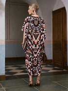 A person wearing the Social Queen Geometric Motif Print Silk Dress (scarf included) and heels stands indoors on tiled flooring, facing away from the camera.