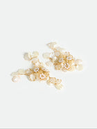 The Social Queen Floral Pearl Drop Earrings feature a gold-tone floral design with ivory petal-shaped accents and delicate pearl details, shown against a plain white background.