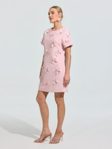 A woman models the Social Queen Beaded Floral Appliqué Dress, an elegant light pink shift adorned with 3D florals—perfect for special occasions.