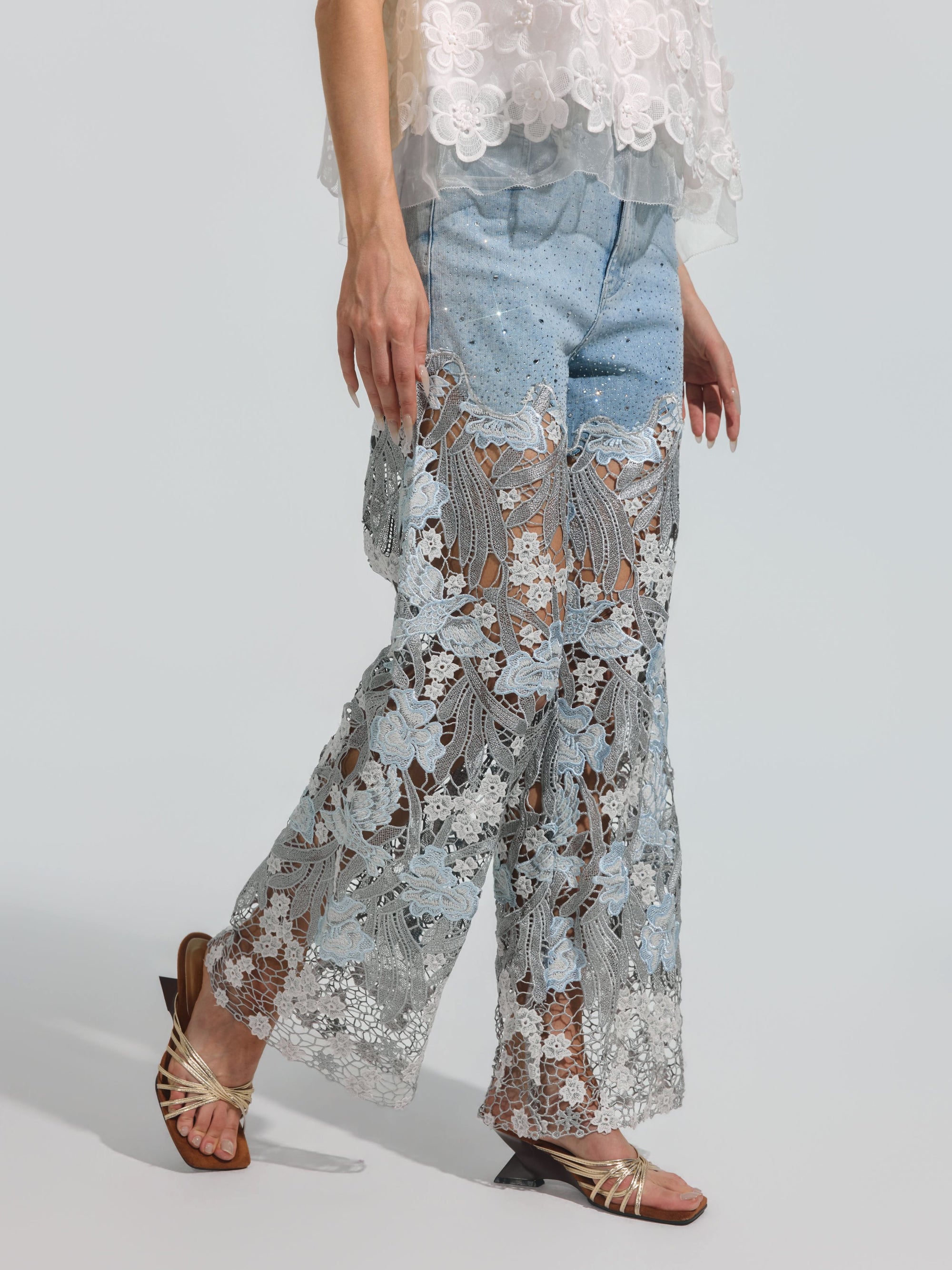 A person is wearing the Social Queen Floral Lace Patchwork Pants over light blue stretch denim shorts, styled with a matching lace top and sandals.