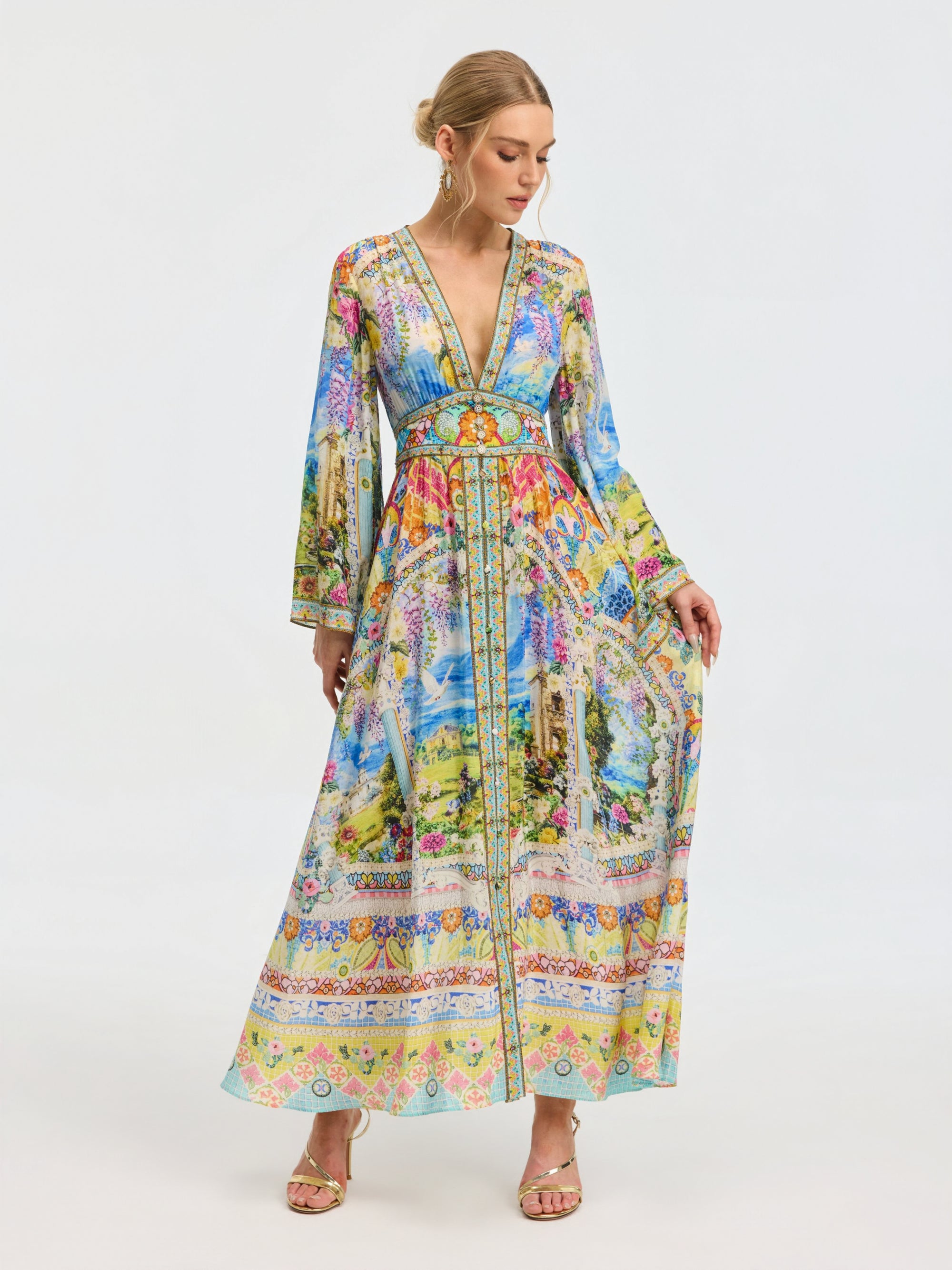 A woman models the Social Queen Garden Print Silk Maxi Dress, featuring a deep V-neck, long sleeves, and a fitted waist, against a plain white background.