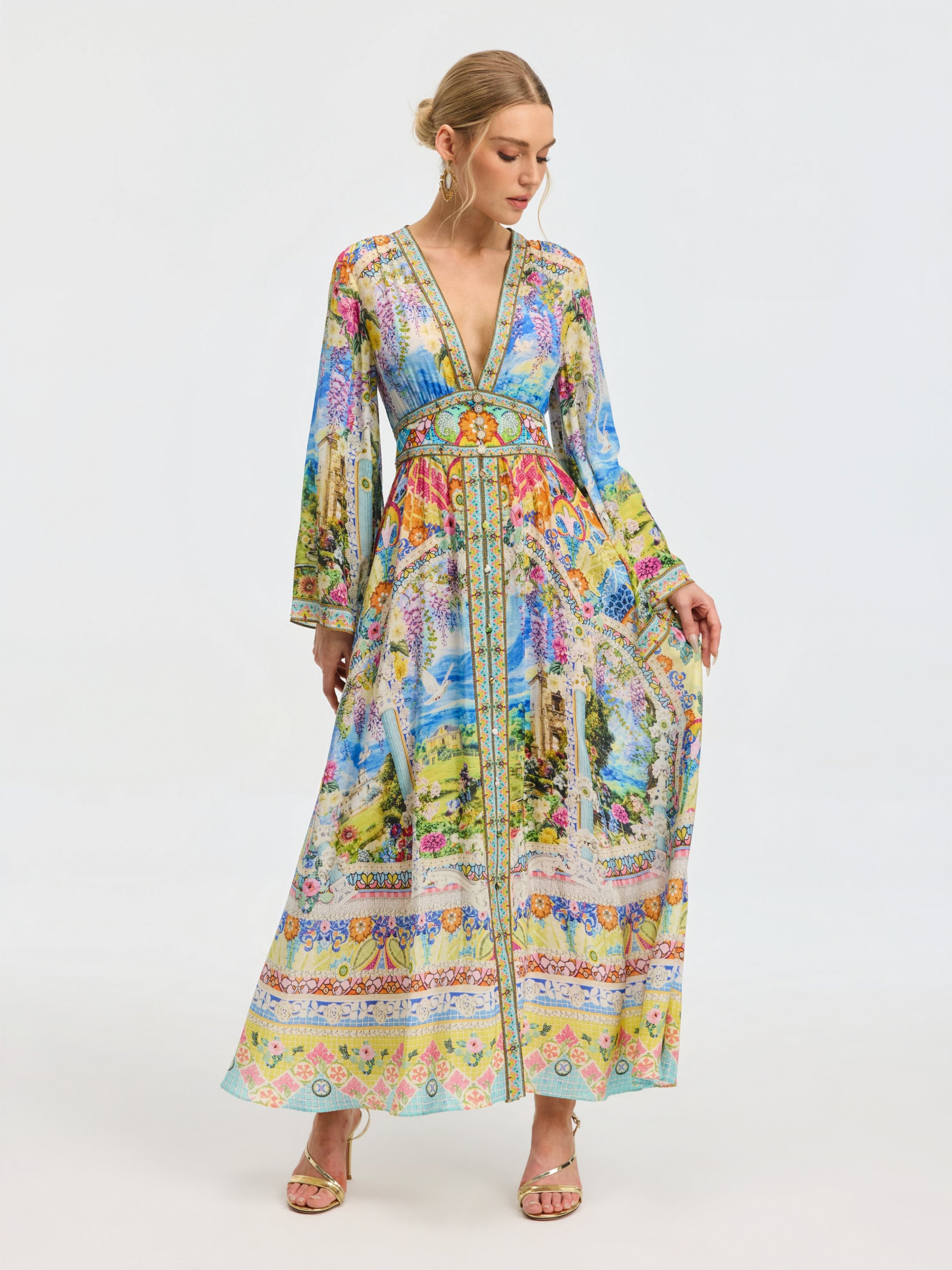 A woman models the Social Queen Garden Print Silk Maxi Dress, featuring a deep V-neck, long sleeves, and a fitted waist, against a plain white background.