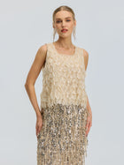 A woman wearing the Social Queen 3D Leaf Beaded Mesh Top with a sleeveless beige dress, featuring scalloped detailing on the bodice and silver fringe sequins on the skirt, stands against a plain light background.