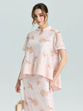A woman wearing the Social Queen Dragonfly Beaded Lace Top in light pink with floral embroidery and an elegant A-line shape stands against a plain background, holding a beige handbag.