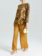A person wears the Social Queen Flocked Floral Silk Sheer Top (Camisole Not Included) styled with gold wide-leg pants, beige heeled sandals, and a small cream handbag, standing against a plain light backdrop.