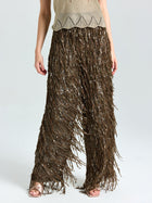 A person wears Social Queen’s Sequin Fringe Wide-Leg Pants, styled with a beige knit top and open-toe sandals.