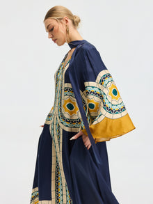 A woman stands in profile against a plain background, wearing the Social Queen Moroccan Print Silk Caftan Dress with matching long outerwear.