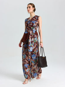 A woman wears the Social Queen Floral Print Fringe Tie-Front Top, styled with a dark handbag, heeled sandals, and jewelry, standing against a plain background.
