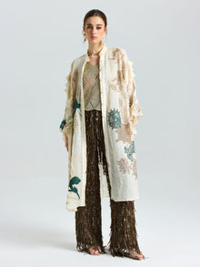 A woman models the Social Queen Floral Embroidered Linen Jacket (Cami Included) with a metallic top and brown fringed pants, posing against a plain white background.