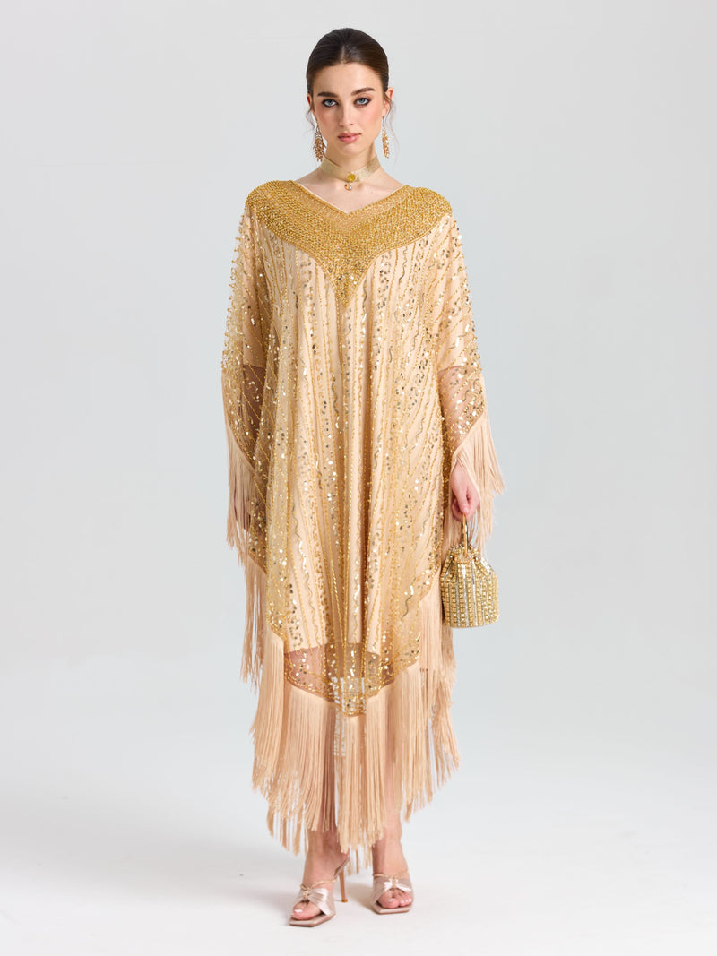 A woman faces forward in the Social Queen Beaded Fringe Cape Dress, styled with matching earrings and a small beaded handbag. She wears light makeup and has her hair pulled back.