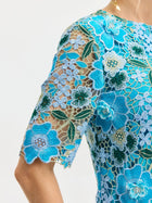 Close-up of a person wearing the Social Queen Floral Appliqué Lace Shift Dress with sheer sleeves and embroidered floral lace.