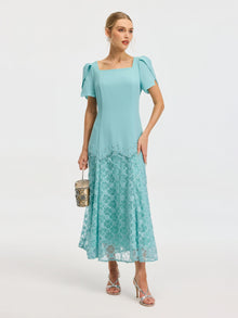 Model wearing the Social Queen Beaded Floral Lace Patchwork Dress with puff sleeves and a lace skirt, accessorized with a small handbag and silver sandals. Ideal elegant occasionwear for special events.