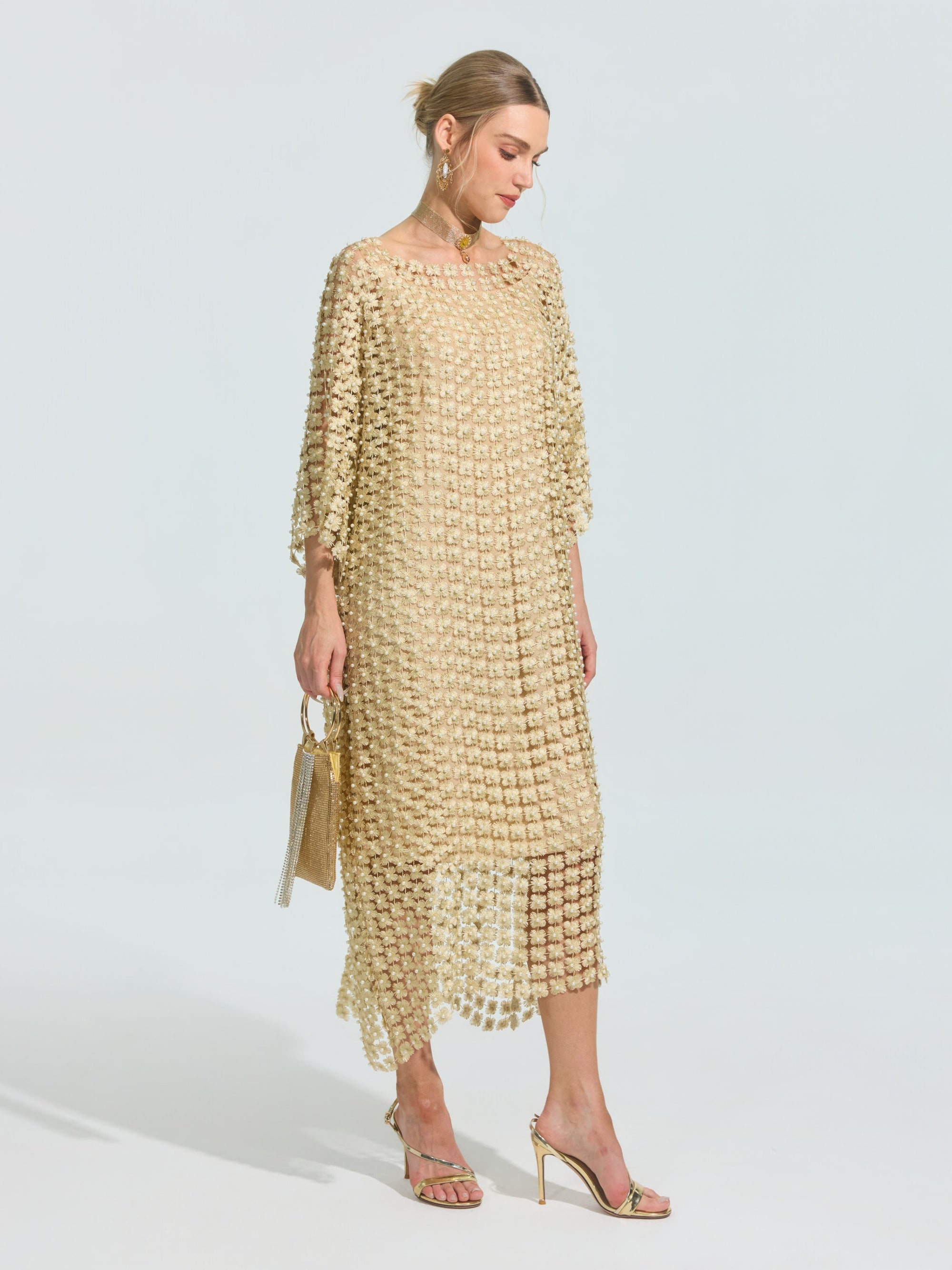 A woman wears the Social Queen Pearl Embellished Floral Overlay Dress (Slip Dress Included) with gold high-heeled sandals and a small gold handbag, standing against a plain background.