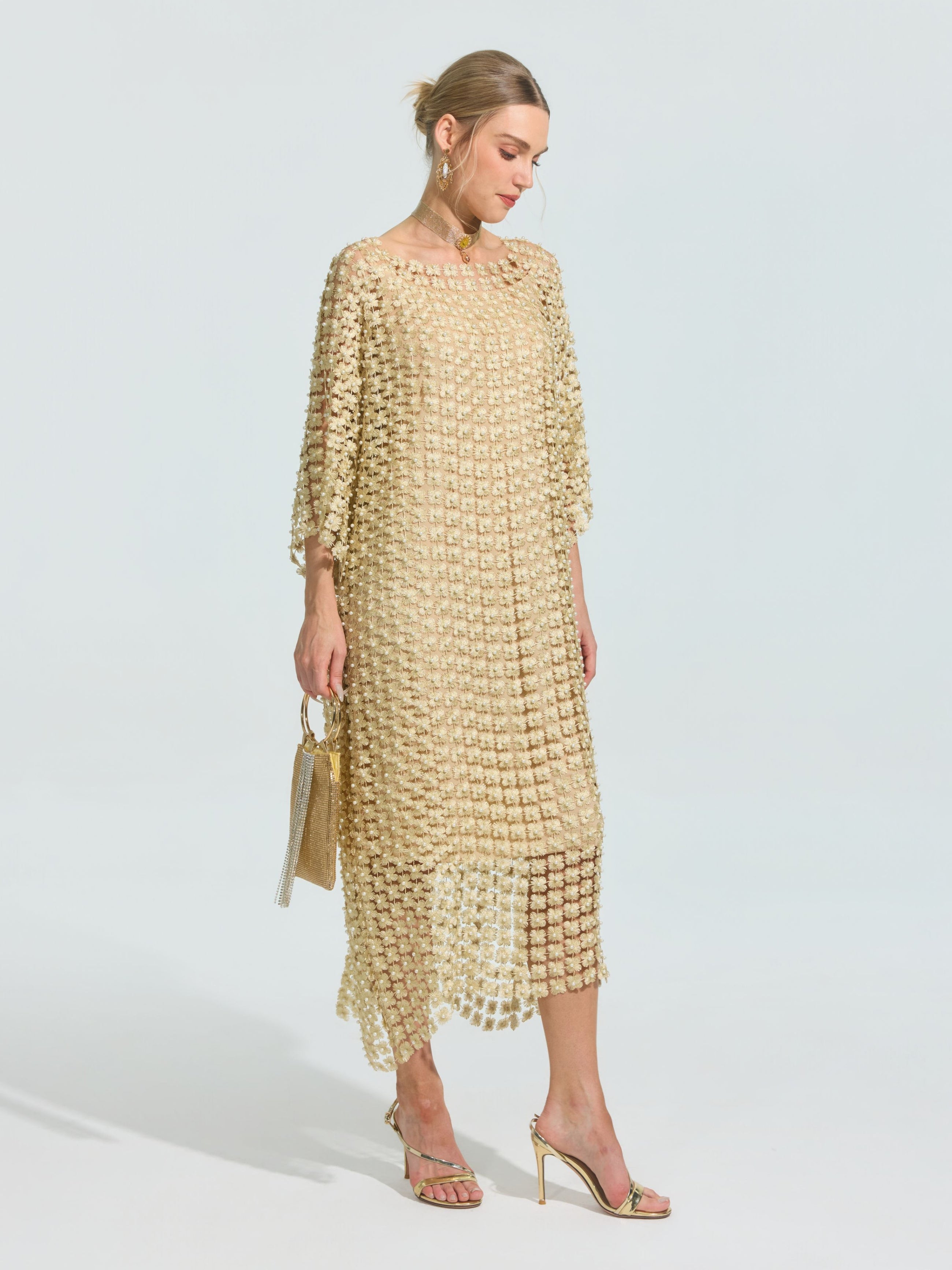 A woman wears the Social Queen Pearl Embellished Floral Overlay Dress (Slip Dress Included) with gold high-heeled sandals and a small gold handbag, standing against a plain background.