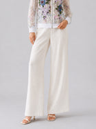 A person is wearing Social Queen’s Casual Wide-Leg Pants in white, styled with open-toed heels and a floral lace jacket, standing against a plain background.