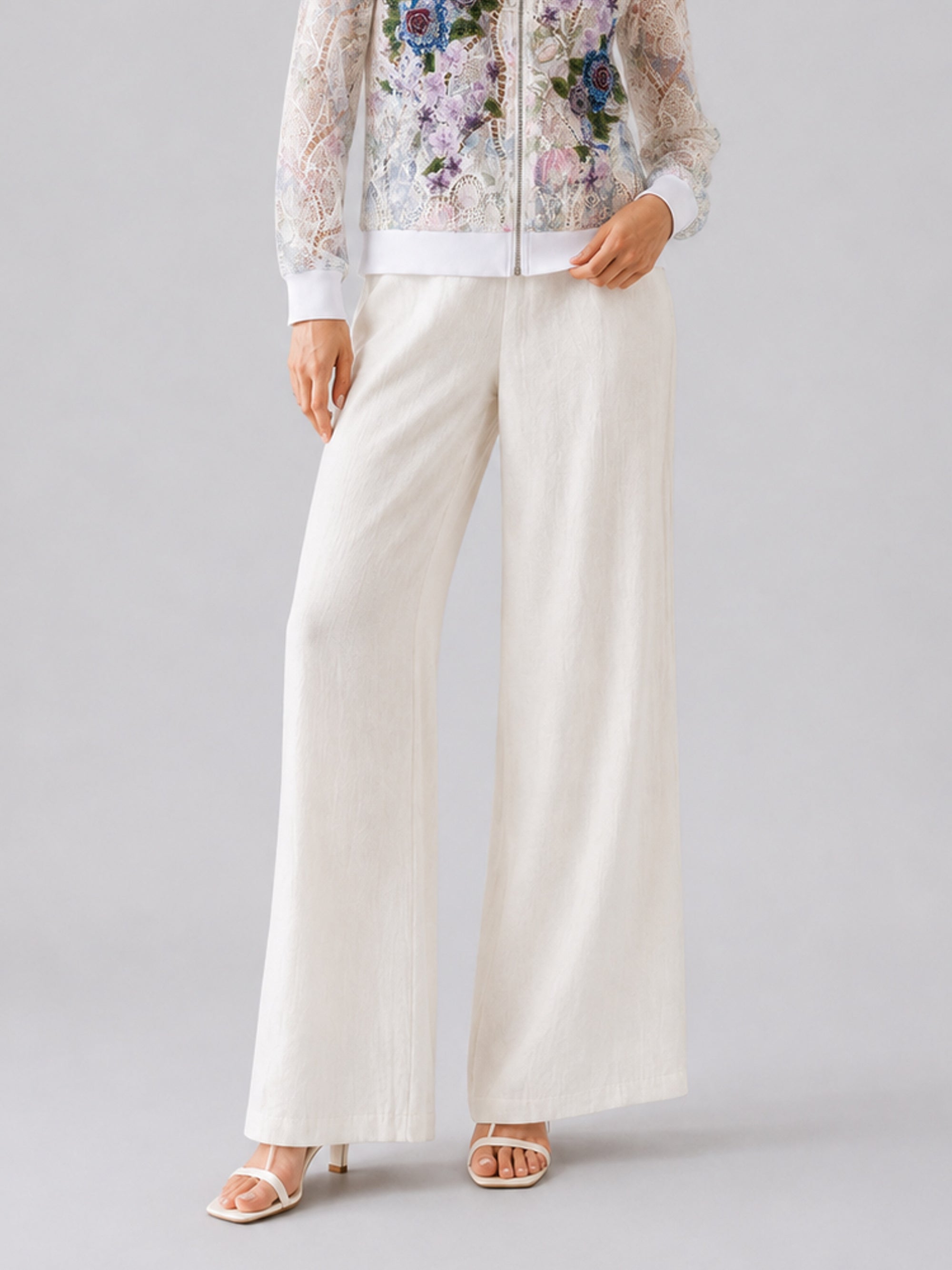 A person is wearing Social Queen’s Casual Wide-Leg Pants in white, styled with open-toed heels and a floral lace jacket, standing against a plain background.