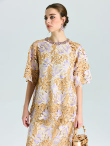 A woman wears the Social Queen Floral Embroidered Lace Top with short sleeves, holding a metallic handbag and looking slightly to the side.