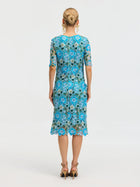 A woman faces away wearing the Social Queen Floral Appliqué Lace Shift Dress with blue water-soluble lace, short sleeves, and knee-length hem, paired with beige high-heeled sandals against a plain white background.