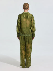 A person stands facing away, wearing Social Queen's Beaded Botanical Burnout Satin Shirt with matching wide-leg pants against a plain light background.