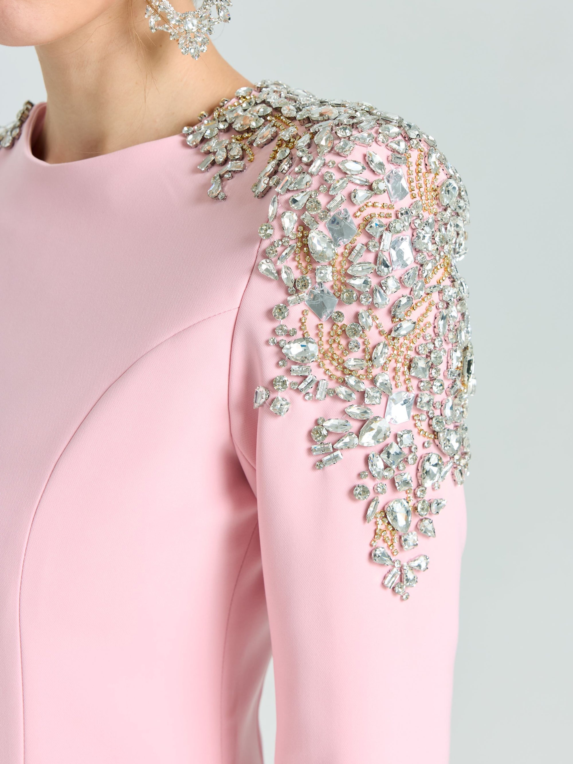 A person wears the Social Queen Crystal Beaded Detail Midi Dress in light pink crepe, featuring ornate silver and gold crystal beading on the shoulder; only upper torso and part of face are visible—ideal for elegant evening events.