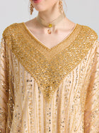A woman wears the Social Queen Beaded Fringe Cape Dress with a V-neckline, styled with a beige choker necklace and gold earrings.