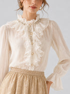 A woman wearing the Social Queen Pearl Embellished Ruffle Collar Blouse, styled with a beige patterned skirt.
