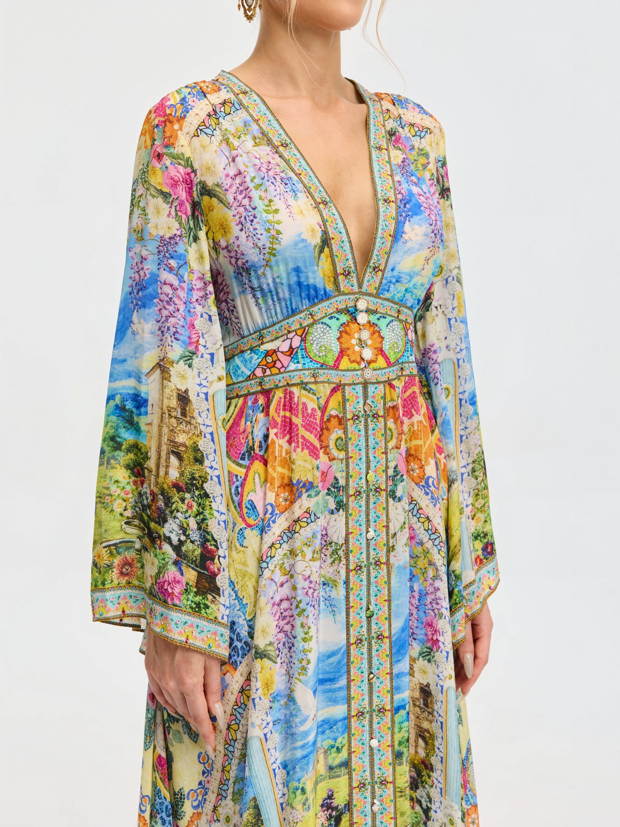 A woman wears the Social Queen Garden Print Silk Maxi Dress, a long-sleeved V-neck dress made from mulberry silk with vibrant garden-inspired and architectural patterns.