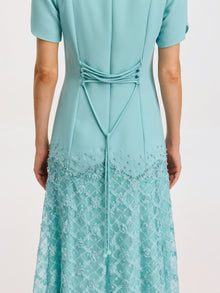 A person wears the Social Queen Beaded Floral Lace Patchwork Dress in light blue, facing away to display the decorative tied cord and intricate lace and bead details.