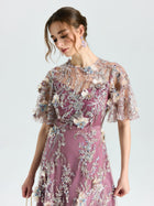 Model wears the Social Queen Floral Beaded A-Line Dress, featuring mauve floral embroidery, sheer embellished sleeves, and delicate details, standing against a plain light background.