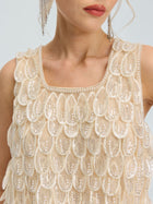 A woman wearing the Social Queen 3D Leaf Beaded Mesh Top, featuring layered sequin-embellished oval patterns and 3D leaf appliqués, paired with dangling earrings.