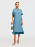 A woman wears the Social Queen Beaded Crystal Embellished Dress with ruffled sleeves and hem, silver heels, statement earrings, and carries a small patterned handbag.