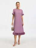 A woman wears the Social Queen Beaded Crystal Embellished Dress—a lavender, knee-length shift with a beaded neckline, ruffle hem and sleeves, and floral appliqués—paired with a round bag, strappy heels, and statement earrings.