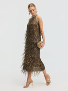 A woman wears the Social Queen Beaded Sequin Fringe Halter Top, paired with gold high heels and a small gold clutch, standing against a plain white background.