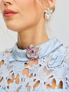 Woman wearing a light blue lace dress, adorned with the Social Queen Gradient Peony Rhinestone Brooch on the collar, and a flower-shaped pearl earring.
