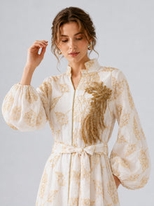 A woman wearing the Social Queen Leaf Embroidered Beaded Dress, featuring gold embroidery, a belt, and gold beaded embellishment on the chest, stands against a plain light background.