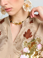 Woman wearing Social Queen Daisy Cluster Earrings, a gold necklace with gemstones, and an embroidered beige top with sequin flowers.