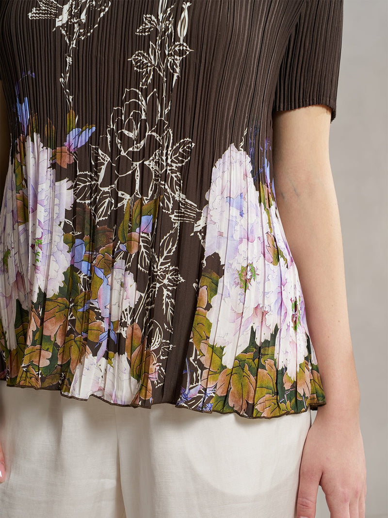 A person styles the Social Queen Ink Floral Print Plissé Top with light-colored pants—a chic choice for a wedding guest outfit.